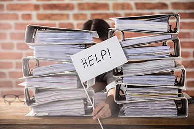 Woman behind pile of binders